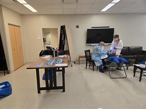Dentist and assistant working on a student's mouth. 